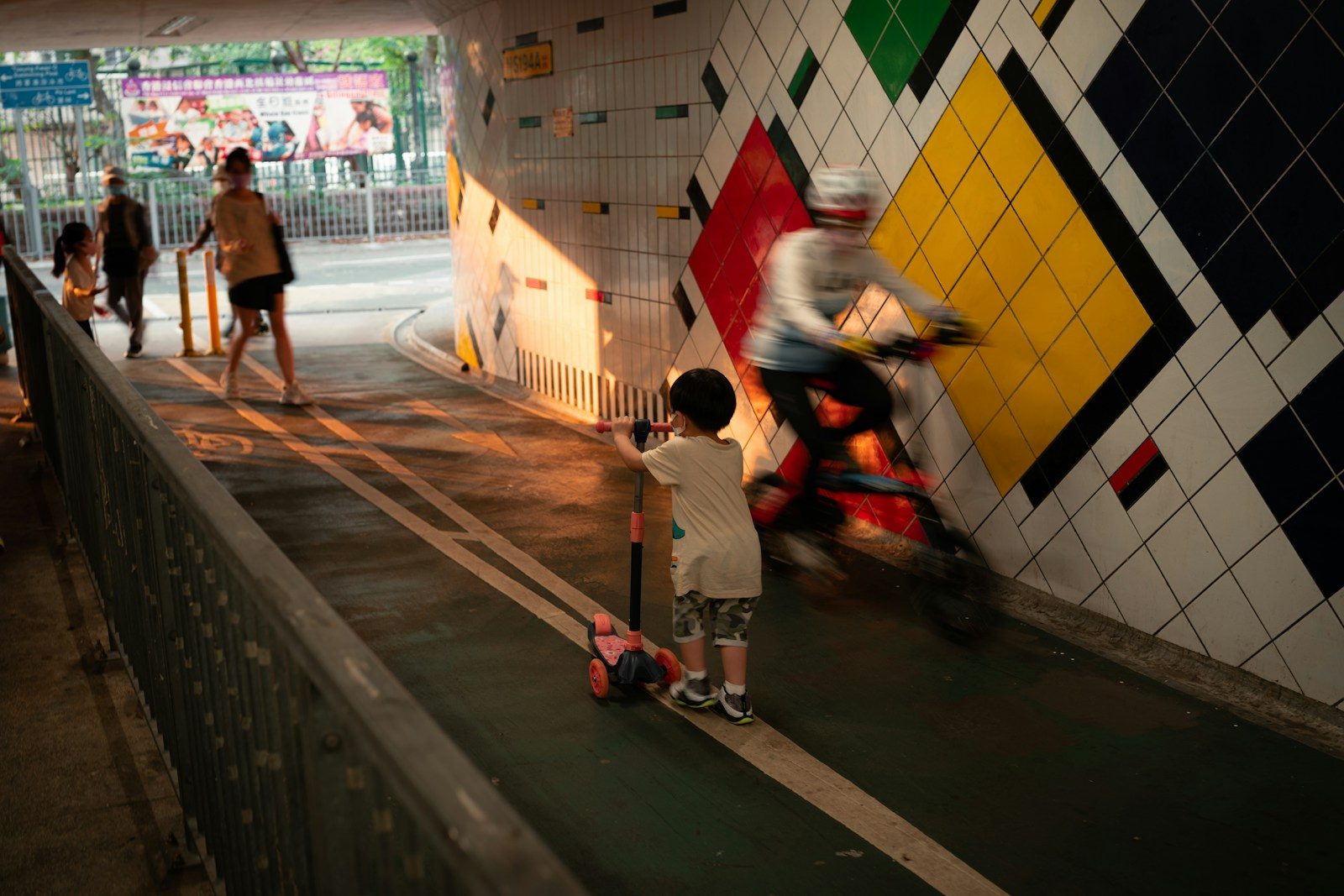 man in white t-shirt and black shorts holding red kick scooter